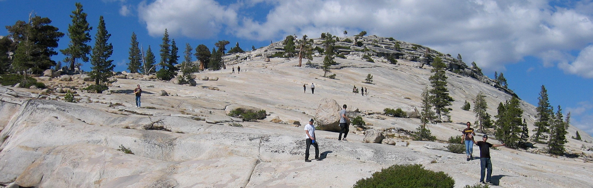 Students climbing on large granite formation